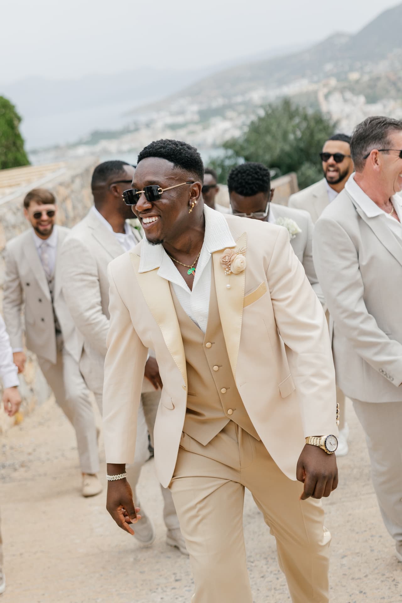 Groom in a cream three-piece suit with his party